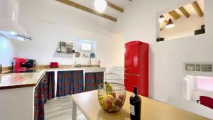 a kitchen with a red refrigerator and a table with a bowl of fruit at The Cliffs - La Maison du Puits in O Barqueiro