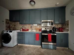 a kitchen with green cabinets and a stove and a microwave at Windy Bottom in Saint Philip