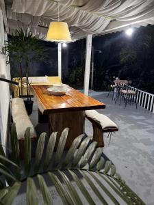 una mesa de madera y sillas en un patio por la noche en Casinha Branca da Cascata, Lumiar, en Lumiar