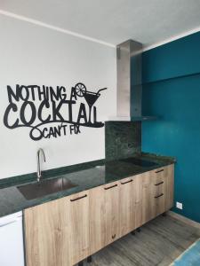 a kitchen with a counter and a sign on the wall at A Praia, My Own Paradise- Estúdio in Figueira da Foz +12 photos