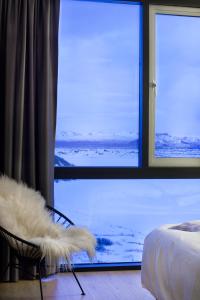 a room with a bed and a chair with a window at ION Adventure Hotel, Nesjavellir, a Member of Design Hotels in Nesjavellir