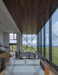 a living room with a couch and large windows at ION Adventure Hotel, Nesjavellir, a Member of Design Hotels in Nesjavellir