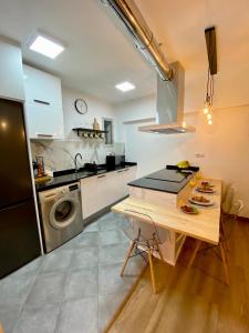 a kitchen with a table and a sink and a dishwasher at Apartamentos en Gascona Centro de Oviedo Apartastur26 in Oviedo