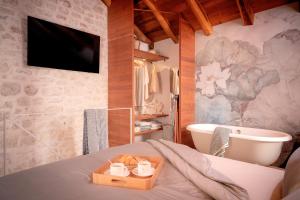 フヴァルにあるBaby Blue - ZF Hvarのバスタブとキャンドルのトレイが置かれたベッドのある寝室