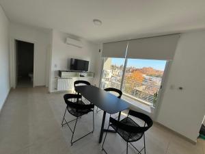 a dining room with a table and chairs and a window at Suite Centro Junin in Junín