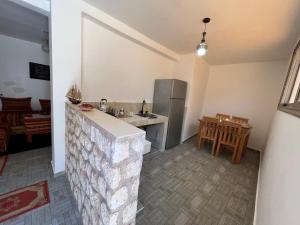 a kitchen with a counter and a table and a refrigerator at Maison de KAOUKI in Essaouira