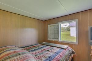 un dormitorio con una cama y una ventana en Honesdale Cabin on 110-Acre Farm Pets Welcome!, en Honesdale