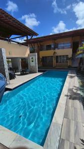 a swimming pool in front of a house at Condomínio Reserva dos Corais in Cabo de Santo Agostinho