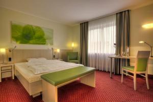 a hotel room with a bed and a table and chairs at Hotel Schiller in Olching +89 photos