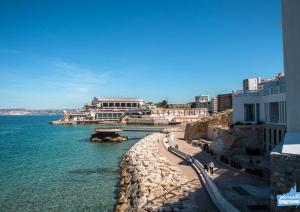 a view of the ocean and a beach with buildings at Vallon des auffes - proche mer in Marseille