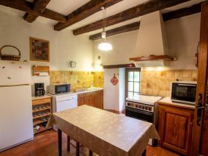 Una cocina con un refrigerador blanco y una mesa. en Maison familiale isolée 4 chambres à la campagne d'Eymet - FR-1-616-30, en Eymet 12 fotos más