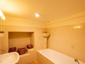 Un baño con bañera blanca y lavabo. en Maison familiale isolée 4 chambres à la campagne d'Eymet - FR-1-616-30, en Eymet