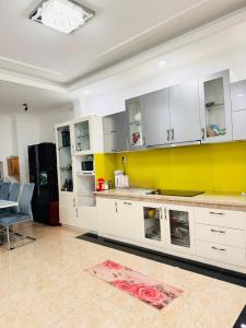 胡志明市Homestay Phu Dinh District 8的厨房配有白色橱柜和黄色墙壁