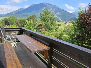 d'un banc en bois sur un balcon avec vue sur les montagnes. dans l'établissement alpinzeit.bayern Tanja und Thomas Preinfalk inkl. Chiemgaukarte, à Ruhpolding