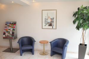 dwa niebieskie krzesła i stół w poczekalni w obiekcie Hotel Sonne w mieście Leinfelden-Echterdingen