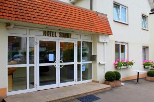 a hotel entrance with a sign on the front of a building at Hotel Sonne in Leinfelden-Echterdingen