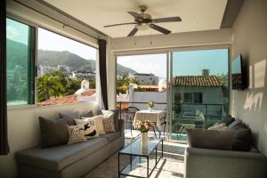 a living room with couches and a large window at Makari Vallarta in Puerto Vallarta
