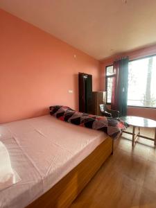 a bedroom with a large bed and a table at Sattva Retreat One Bedroom Chalets in Almora