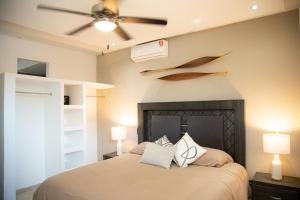 a bedroom with a bed with a ceiling fan at Makari Vallarta in Puerto Vallarta