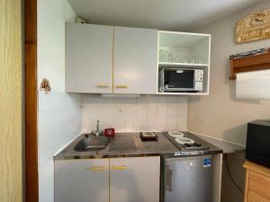 a small kitchen with a sink and a microwave at Studio calme avec balcon sud, parking, 4 pers max – Abondance - FR-1-692-100 in Abondance +4 photos