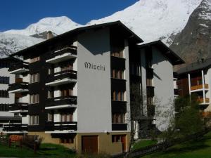 a apartment building with a mountain in the background at Mischi in Saas-Fee