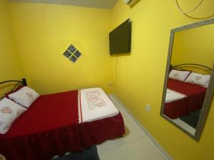 a small bedroom with a bed and a mirror at Aconchego Ramos 02 in Carolina