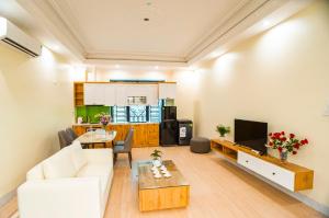 un salon avec un canapé blanc et une table dans l'établissement The Paradise Apartment - 68 Luong Van Thang, Ninh Binh City, à Ninh Binh