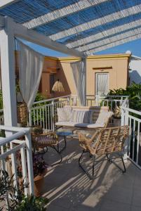 eine Terrasse mit Stühlen und einem Sofa auf dem Balkon in der Unterkunft Ioli's Home - Medieval Town in Rhodos (Stadt)