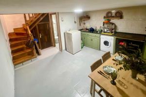 a kitchen with a table and a white refrigerator at VilladeCelis in Mieres