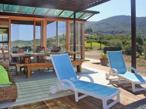 a patio with blue chairs and a wooden table at Holiday Home Magazzini with Sea View in Magazzini