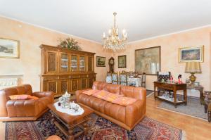 ein Wohnzimmer mit Ledermöbeln und einem Kronleuchter in der Unterkunft Appartamento Via Latina in Collegno