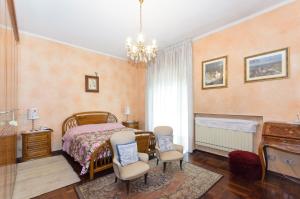 een slaapkamer met een bed en 2 stoelen en een piano bij Appartamento Via Latina in Collegno