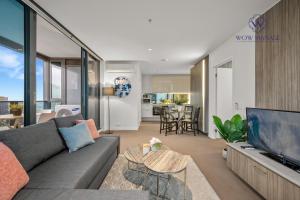 a living room with a couch and a tv at WOW Apartment on Spencer in Melbourne