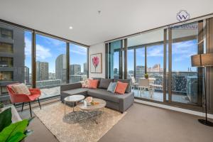 a living room with a couch and glass windows at WOW Apartment on Spencer in Melbourne