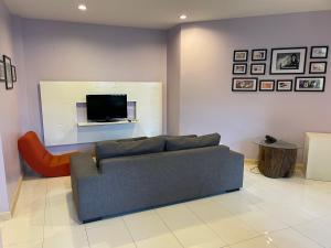 a living room with a couch and a tv at Song Service Apartment formerly known as Jinhold Service Apartment in Kuching