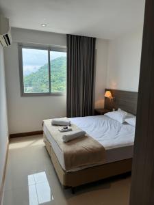 une chambre avec un lit et une grande fenêtre dans l'établissement Flat Midas Rio - Rio centro - Barra olímpica - Jeunesse, à Rio de Janeiro 92 autres photos