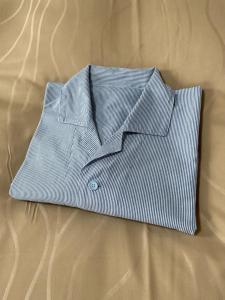 a blue and white striped shirt laying on a bed at Terminal Hotel Matsuyama in Matsuyama