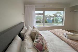 比那隆湾TOP DECK - Panoramic water views of the Bay of Fires的一间带床的卧室，配有大窗户