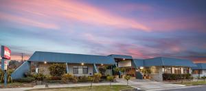 蒂默特Amaroo Motel Tumuts Best Accommodation的多云天空下的蓝色屋顶建筑