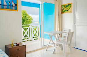 a room with a table and chairs and a view of the ocean at Shamar Lodge in Providencia