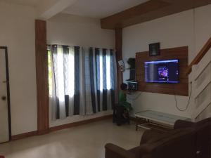 エルニドにあるDishan Homestay El Nidoのテレビのあるリビングルームに座っている少年