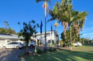 due auto parcheggiate di fronte a un edificio con palme di Beachmere Palms Motel a Beachmere Altre 36 foto