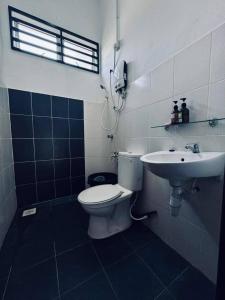 a bathroom with a toilet and a sink at Casaria Homestay Cherating in Kampong Baharu Cherating +9 photos