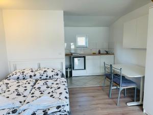 a room with a bed and a table and a kitchen at Bright Side Studios in Ljubljana