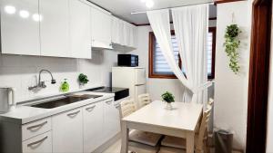 a kitchen with white cabinets and a white table and chairs at Dream Attic Seoul in Seoul
