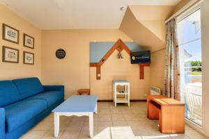 ein Wohnzimmer mit einem blauen Sofa und einem Tisch in der Unterkunft Résidence Belle Dune - maeva Home - Appartement 2 pièces 4 personnes - Sélection MAE-3751 in Fort-Mahon-Plage