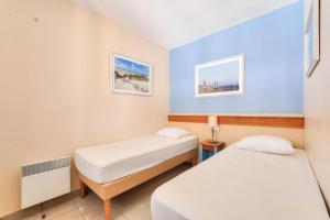 2 Betten in einem kleinen Zimmer mit blauen Wänden in der Unterkunft Résidence Belle Dune - maeva Home - Appartement 2 pièces 4 personnes - Sélection MAE-3751 in Fort-Mahon-Plage