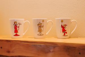 four coffee cups sitting on a wooden shelf at Rezi Pava in Pava