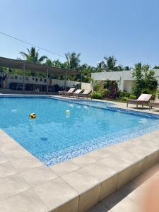 a swimming pool with chairs and a ball in the water at Fukuchani Inn Hotel in Kigongoni