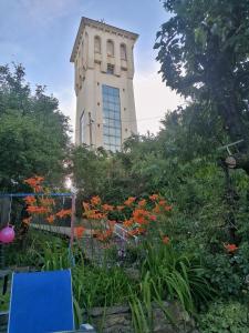 un edificio con una torre con un mazzo di fiori di Magični kutak Magical corner a Vranje